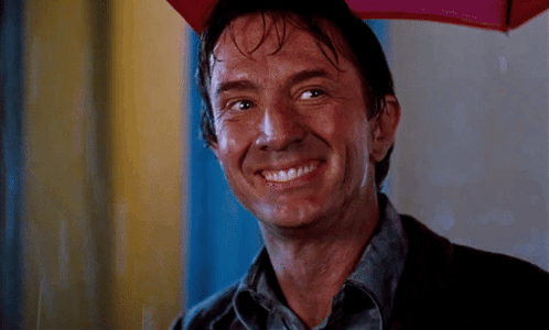 A Man Is Smiling While Holding A Red Umbrella GIF