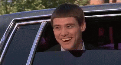 A Man Is Smiling While Sitting In A Car With His Head Out The Window . GIF