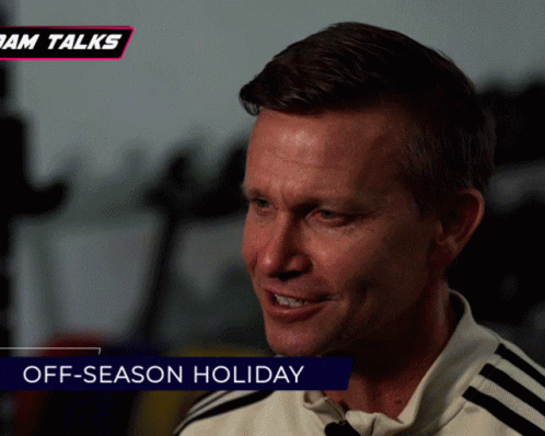 a man is smiling with the words off-season holiday behind him