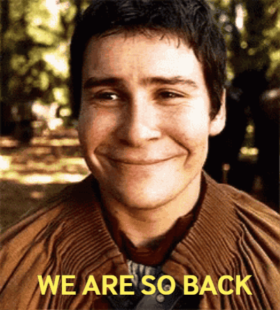 A Man Is Smiling With The Words We Are So Back Above Him GIF