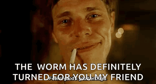 A Man Is Smoking A Cigarette And Smiling With The Words `` The Worm Has Definitely Turned For Your Friend '' . GIF