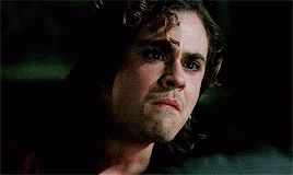 A Man Is Smoking A Cigarette In A Dark Room . GIF