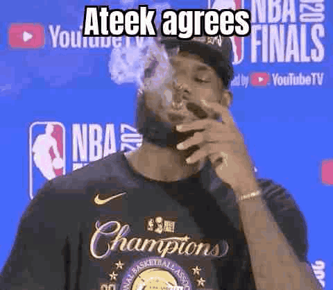 A Man Is Smoking A Cigarette In Front Of A Basketball Player Wearing A Championship Shirt . GIF