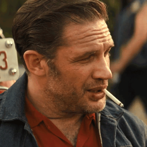 a man is smoking a cigarette in front of a license plate that says 3