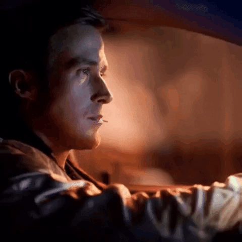 A Man Is Smoking A Cigarette While Driving A Car In The Dark . GIF