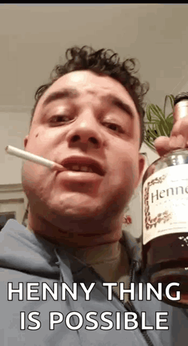 A Man Is Smoking A Cigarette While Holding A Bottle Of Hennessy Cognac . GIF