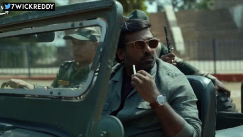 A Man Is Smoking A Cigarette While Sitting In A Car With Wickreddy Written On The Bottom GIF