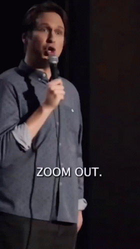 A Man Is Speaking Into A Microphone And The Words Zoom Out Are Above Him GIF