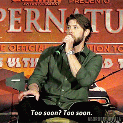 a man is speaking into a microphone in front of a sign that says pernuatu