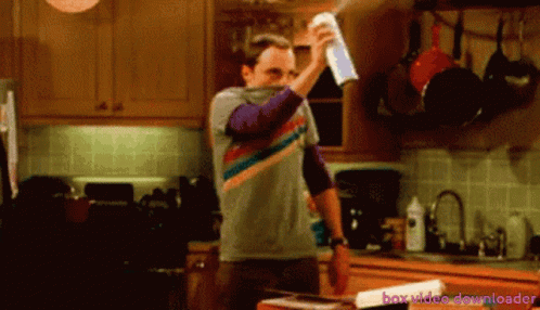 A Man Is Spraying Something In A Kitchen With The Words Box Video Downloader Behind Him GIF