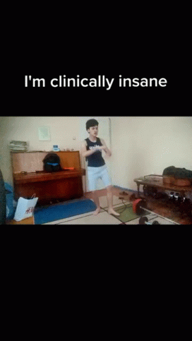 A Man Is Squatting On The Floor In A Living Room With The Words " I 'M Clinically Insane " On The Bottom GIF