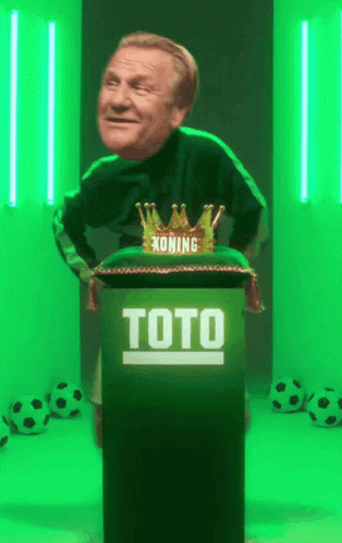 A Man Is Standing Behind A Podium That Says Toto On It GIF