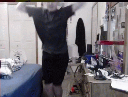 A Man Is Standing In A Bedroom With His Arms Outstretched And A Basketball Jersey On The Wall . GIF