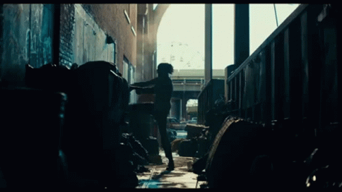 Man Standing In Dark Alley With Trash GIF