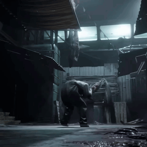 A Man Is Standing In A Dark Room With A Light Shining On Him GIF