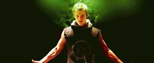 A Man Is Standing In A Dark Room With His Arms Outstretched And A Red Shirt On . GIF