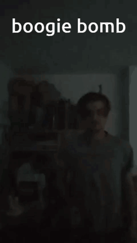 A Man Is Standing In A Dark Room With The Words Boogie Bomb Written Above Him GIF