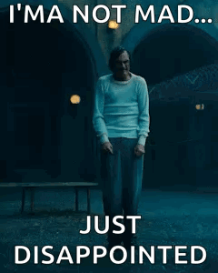 A Man Is Standing In A Dark Room With The Words `` I 'M Not Mad ... Just Disappointed '' Written On It . GIF