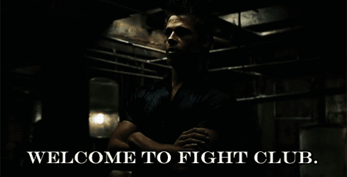 A Man Is Standing In A Dark Room With The Words Welcome To Fight Club GIF