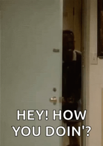 A Man Is Standing In A Doorway Talking To Another Man . GIF