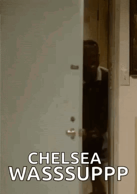 A Man Is Standing In A Doorway With The Words `` Chelsea Wasssuppp '' Written On It . GIF