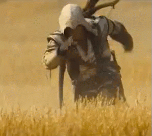 a man is standing in a field of wheat holding a knife .