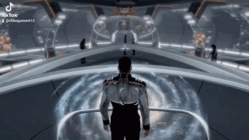 A Man Is Standing In A Futuristic Room In A Video Game And Looking At Something . GIF