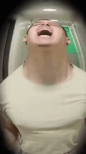 a man is standing in a hallway with his mouth open and looking up .