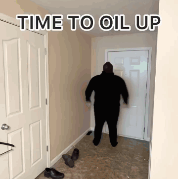 A Man Is Standing In A Hallway With The Words Time To Oil Up Written Above Him GIF