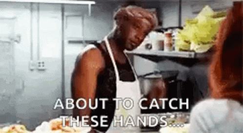 A Man Is Standing In A Kitchen Talking To A Woman . GIF