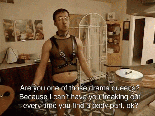 A Man Is Standing In A Kitchen With A Bird Cage In The Background GIF