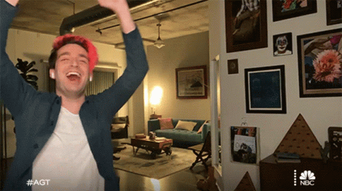 A Man Is Standing In A Living Room With His Arms In The Air And #Agt Written On The Bottom Right GIF