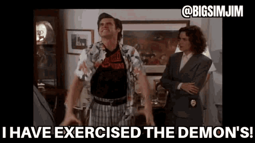 A Man Is Standing In A Living Room With His Arms Outstretched And A Woman Standing Behind Him . GIF