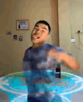 A Man Is Standing In A Pool Of Water With A Cell Phone In His Hand . GIF