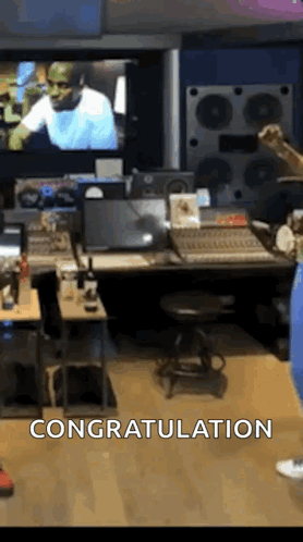 A Man Is Standing In A Recording Studio In Front Of A Large Screen . GIF