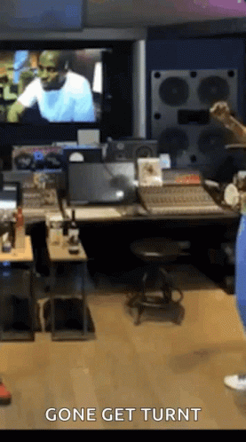 A Man Is Standing In A Recording Studio With The Words Gone Get Turnt On The Bottom Of The Screen . GIF