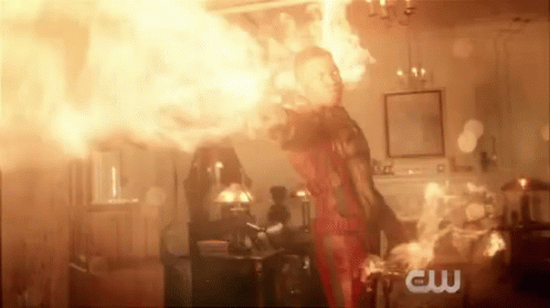 A Man Is Standing In A Room With A Lot Of Fire Coming Out Of His Hands . GIF