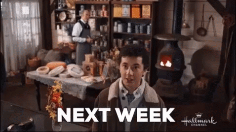 A Man Is Standing In A Room With A Sign That Says Next Week On It . GIF