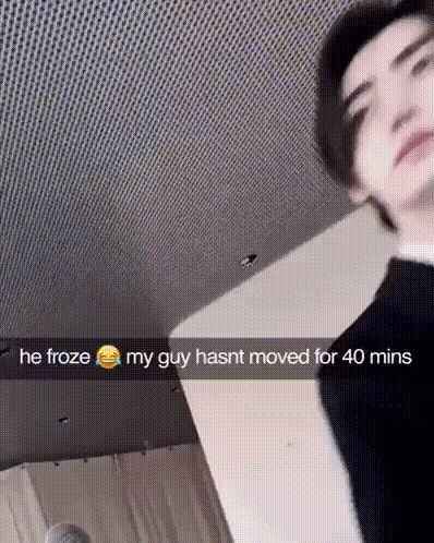 A Man Is Standing In A Room With A Snapchat Caption That Says He Froze My Guy Hasnt Moved For 40 Mins GIF