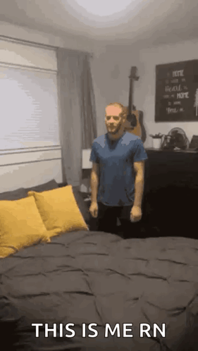 A Man Is Standing In Front Of A Bed With The Words This Is Me Rn On The Bottom GIF
