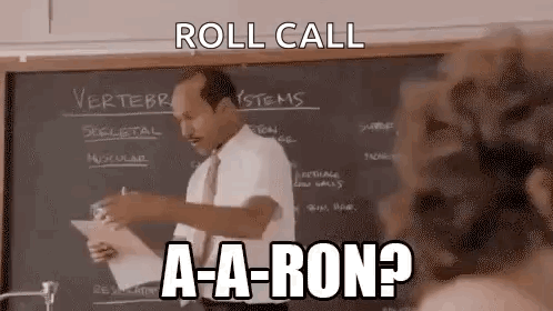 A Man Is Standing In Front Of A Blackboard In A Classroom And Giving A Lecture . GIF