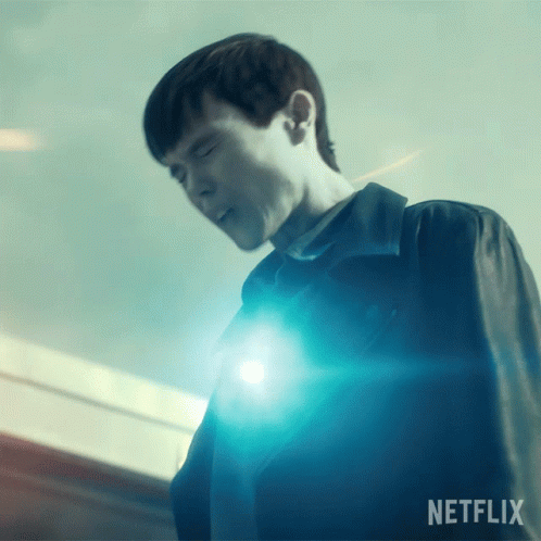 A Man Is Standing In Front Of A Blue Light And The Word Netflix Is On The Bottom GIF