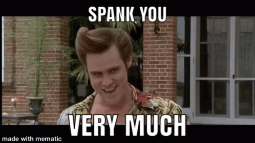 A Man Is Standing In Front Of A Brick Building With The Words `` Spank You Very Much '' Written On It . GIF