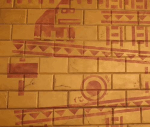 A Man Is Standing In Front Of A Brick Wall With A Drawing Of A Bird On It GIF