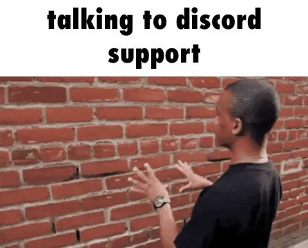 A Man Is Standing In Front Of A Brick Wall With His Hands Outstretched . GIF