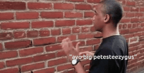 A Man Is Standing In Front Of A Brick Wall With The Words " Ayo Big Petesteezygus " On The Bottom GIF