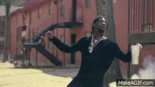 A Man Is Standing In Front Of A Building Holding A Gun And A Cup Of Coffee . GIF
