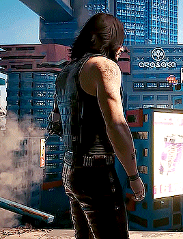 A Man Is Standing In Front Of A Building That Has The Word Osaka On It GIF