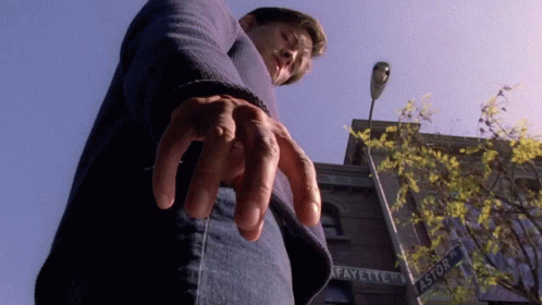 A Man Is Standing In Front Of A Building That Says Fayette On It GIF