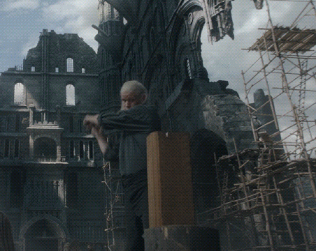A Man Is Standing In Front Of A Building With Scaffolding In Front Of It GIF